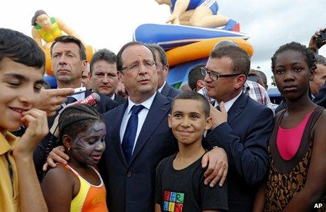 French President Francois Hollande (centre) meets people in Clichy-Sous-Bois, near Paris, 31 July