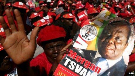 Supporters of Morgan Tsvangirai hold his portrait as they attend the final campaign rally on 29 July