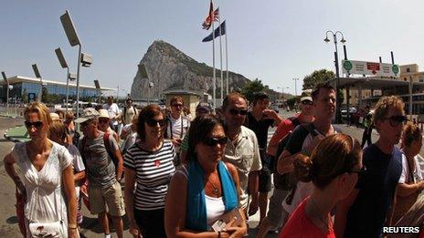 Pedestrians wait to enter to Spain at its border with the British Colony of Gibraltar in front of the Rock
