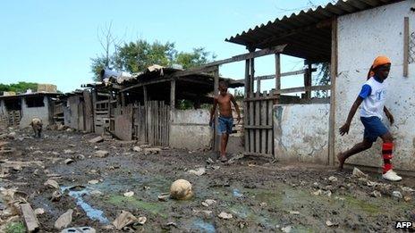 Two children walk past a pig in Cidade de Deus on 31 March 2013