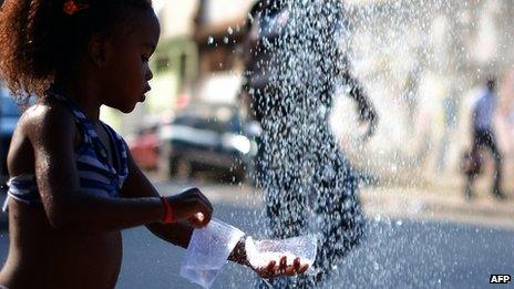 A girl collects water in a street in Cidade de Deus on 31 March 2013