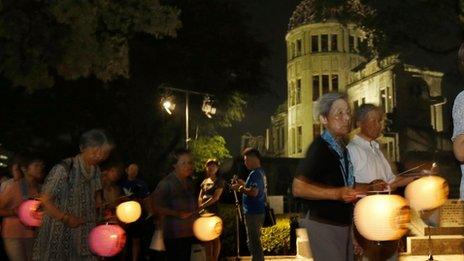 Buddhist followers hold paper lanterns as they march in prayer for peace, around the illuminated Atomic Bomb Dome in Hiroshima, western Japan Monday, 5 Aug 2013