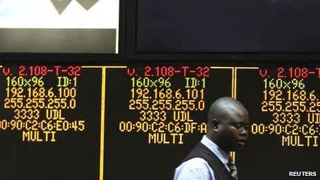 A man walks past an electronic display screen at the close of trading in Harare