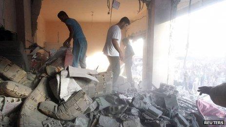 Men search for survivors amid debris of collapsed buildings, after what activists said was shelling by forces loyal to Syrian President Bashar al-Assad in Raqqa province, eastern Syria, 7 August