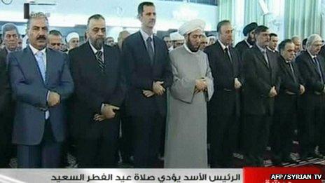 An image grab taken from the state-run Syrian television on 8 August, 2013, shows Syrian President Bashar al-Assad (3rdL) and Syrian Grand Mufti Ahmed Hassun (C) attending the morning prayer of Eid al-Fitr in Damascus.