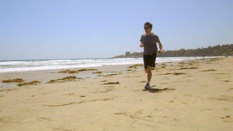 Kevin Fong running along a beach