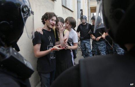 Russian police guard gay rights activists after they were attacked by rival protesters in St Petersburg, 29 June 2013