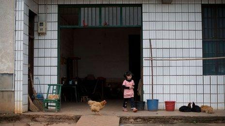 )n April 30, 2012 a child of migrant workers leaves the home she shares with her grandmother in the village of Zhuangshuzui, Hunan province