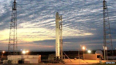 Sun rises over SpaceX's launch pad, and a Falcon 9 rocket and a Dragon spacecraft ready to go to the International Space Station