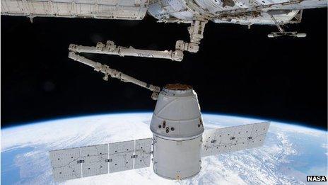 A photo taken by a crew member aboard the International Space Station during the approach, capture and docking of a SpaceX Dragon spacecraft, carried by a Falcon rocket