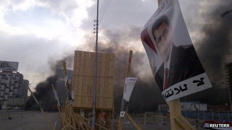 A poster of deposed Islamist President Mohamed Morsi is pictured in front of rising smoke