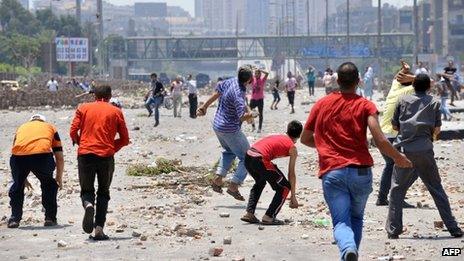 Supporters of the Muslim Brotherhood (foreground) clash with opponents in Cairo