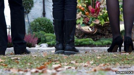 Mourners standing at grave