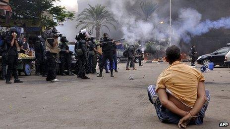A handcuffed protester sits on the ground as Egyptian security forces move in to disperse supporters of Egypt's ousted president Mohamed Morsi in Cairo's Nahda Square on 14 August 2013.