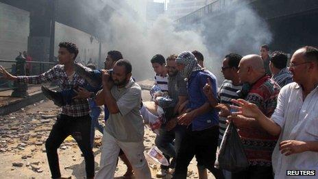 Egyptian Muslim Brotherhood supporters carry a wounded protestor in Cairo's Ramses square on 16 August, 2013.