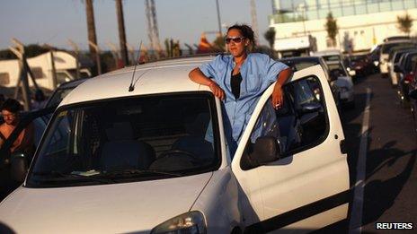 A woman leans out of her car's door in a traffic queue at the Spain-Gibraltar border