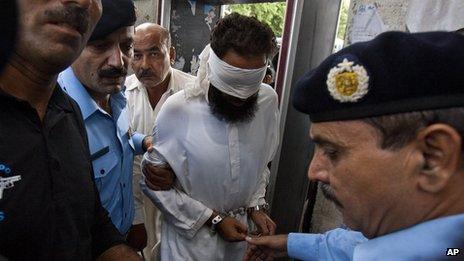 Muslim cleric Khalid Jadoon (blindfolded) is escorted by police in Islamabad (2 Sept 2012)