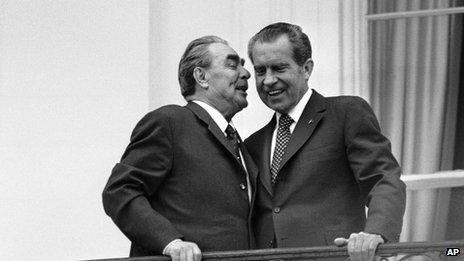 Soviet leader Leonid Brezhnev, left, whispers in the ear of President Richard Nixon as the two leaders stand on a balcony at the White House in Washington 18 June 1973