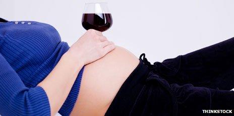 Pregnant woman holding wine glass