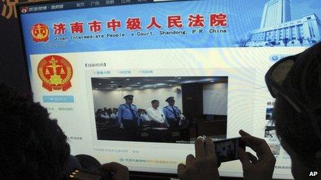 A journalist takes photos of a microblog by Jinan Intermediate People's Court on 22 August 2013