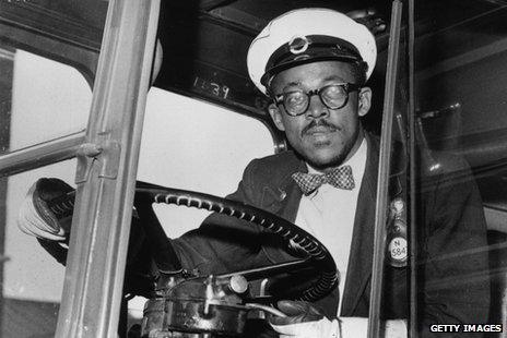 A Black London bus driver at the wheel in the late 1950s