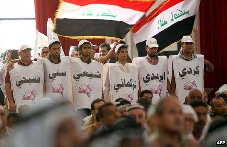 Iraqi men wearing labels in Arabic to identify their different ethnic and religious affiliations, June 2013