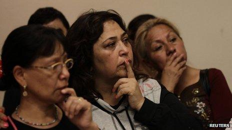 Relatives of 12 people who went missing from a bar in Mexico City listen at a news conference by the prosecutor on 22 August 2013