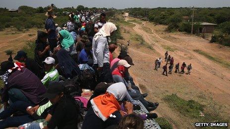 Migrants sit on the roof of La Bestia on 7 August 2013