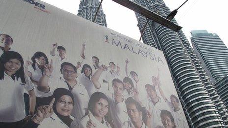 A poster showing Malaysia being a multi-racial country against the Petronas Towers in Kuala Lumpur