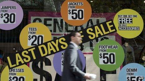 A man walks in front of a shop displaying items on sale in the central business district of Sydney on 5 June 2013