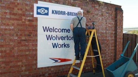 A workman changing the sign at the Railcare site