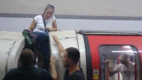 Woman passenger climbing out the window of a smoke-filled train