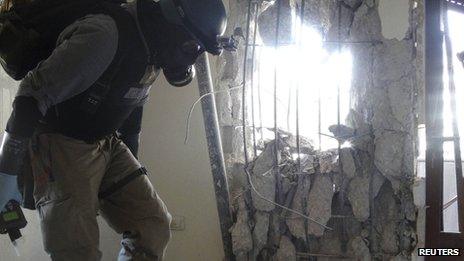 A U.N. chemical weapons expert, wearing a gas mask, inspects one of the sites of an alleged chemical weapons attack in the Damascus" suburb of Zamalka August 29, 2013.