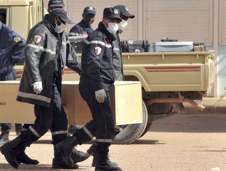 Algerian firemen carry away a coffin