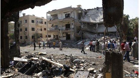 People inspect the damage at a site hit by what activists say was a car bomb in Raqqa province, eastern Syria August 29, 2013