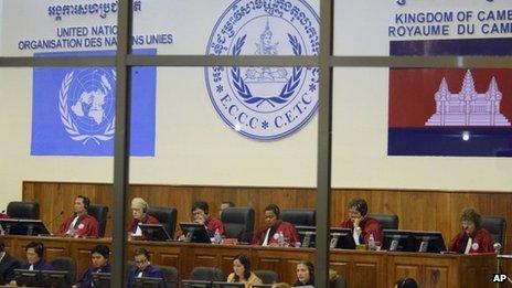 In this 19 October 2011 file photo released by the Extraordinary Chambers in the Courts of Cambodia, court officers of the UN-backed war crimes tribunal are seen through windows during a hearing of former Khmer Rouge top leaders in Phnom Penh, Cambodia