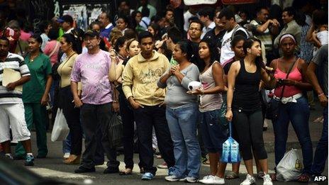 Caracas residents wait for a bus during a power cut on 3 September 2013