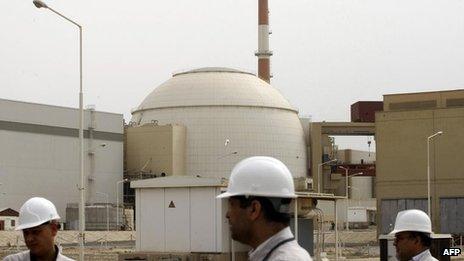 Iranian technicians walk outside the building housing the reactor of Bushehr nuclear power plant