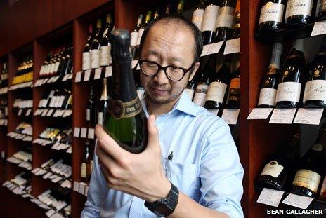 Hector Jiang, assistant shop manager of the Pudao Wines store in central Beijing, inspects a bottle of wine. China. Friday 19 July, 2013