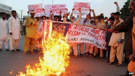 Pakistani activists burn a US flag during a protest against US missile strikes in tribal areas at a rally in Multan on 31 August 2013