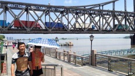 Trucks drive along a bridge connecting Dandong, China with North Korea