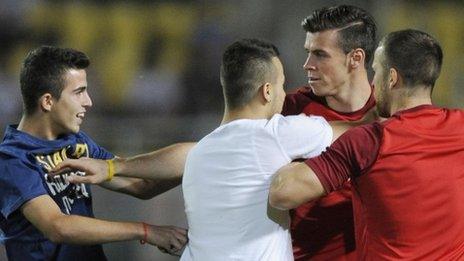 Gareth Bale is accosted by two fans during the World Cup qualifier in Skopje, Macedonia