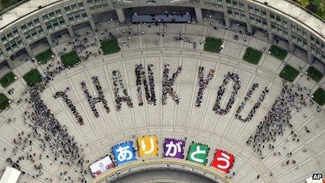 Citizens form "Thank you" to celebrate at the Tokyo Municipal Government office square in Tokyo Sunday, 8 Sept 2013 after the International Olympic Committee chose the city to host the 2020 Olympics