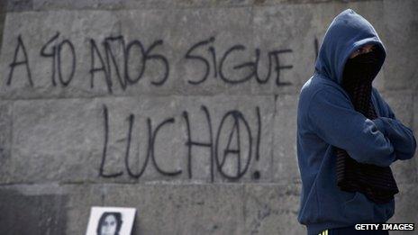 A man stands in front of a graffiti reading "40 years after, the fight continues" during a demonstration opposing the coup in Santiago on 8 September, 2013