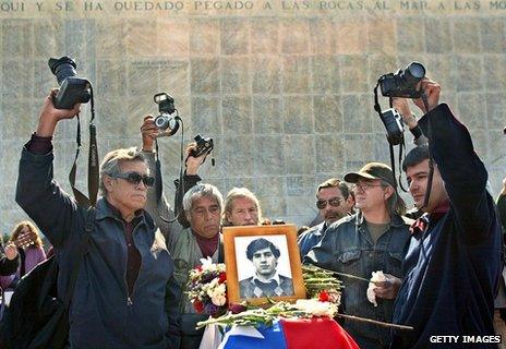 Mourners and photographers around the coffin of Rodrigo Rojas Denegri as his body was relocated in 2003