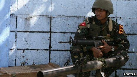 A government soldier squats next to a 90RR shoulder-fired rocket launcher while awaiting orders after Muslim rebels members of the Moro National Liberation Front (MNLF) occupied villages in Zamboanga city, southern Philippines, 9 September 2013