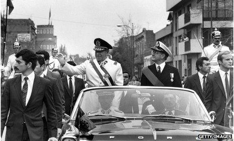 General Augusto Pinochet (l) waves from the motorcade 11 September 1973 in Santiago, shortly after his coup that killed President Allende