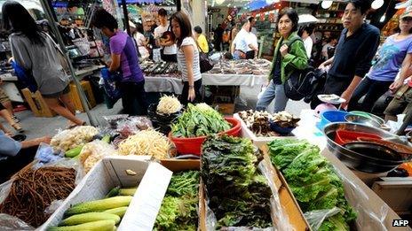 Customers walk past a Seoul Market store before the Chuseok holiday