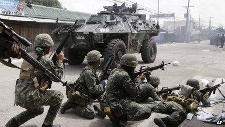 Government troopers aboard an Armoured Personnel Carrier fire at Muslim rebels in an operation to rescue scores of hostages being used as human shields by the rebels on the fourth straight day Thursday, 12 September 2013 at Zamboanga city in southern Philippines