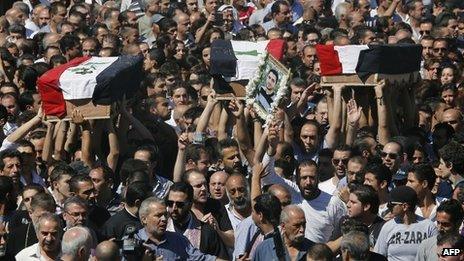 People carry the coffins of three Maaloula residents through the streets of Damascus (10 September 2013)